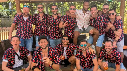 Group of friends wearing matching shirts outdoors.