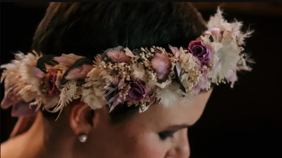 Floral crown on person's head in profile.