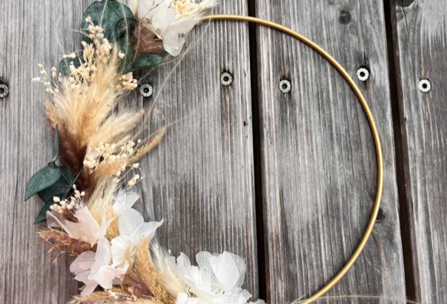 Floral wreath on wooden background.