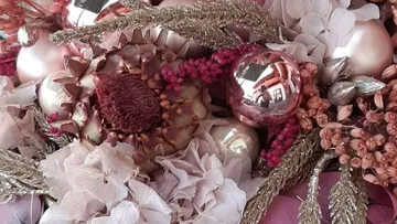Floral arrangement with pink ornaments and dried flowers.