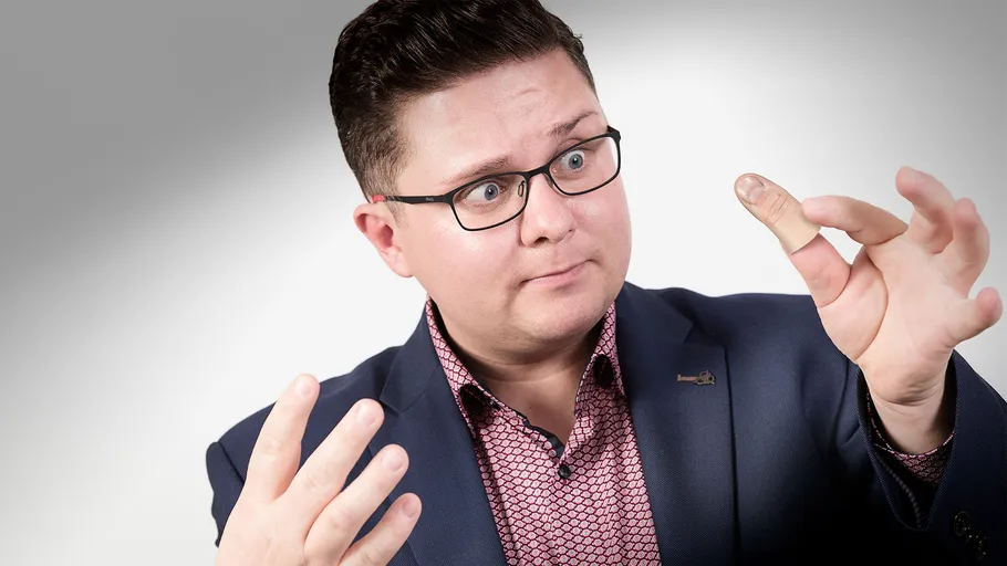 Man wearing suit, extending impressively large thumb.