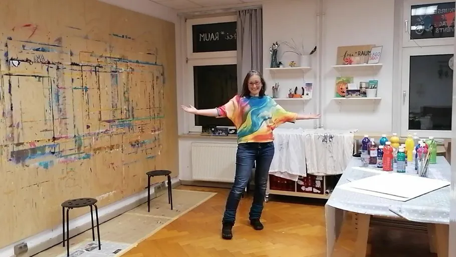 Frau im bunten Shirt posiert im Kunststudio.