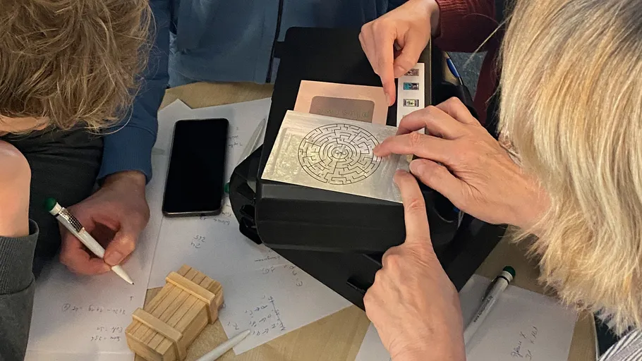 People solving a puzzle with papers and phone.