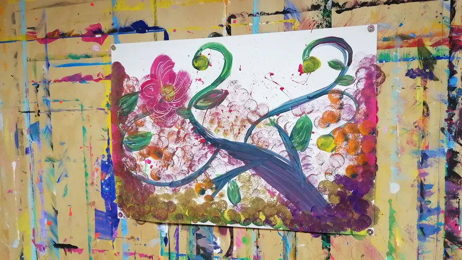 Colorful abstract painting on messy studio wall.