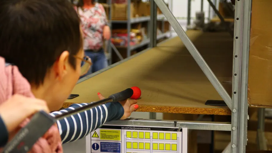 Person inspects shelf with inspection tool.