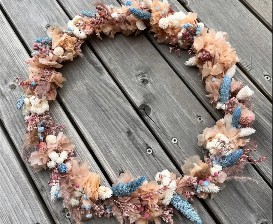 Blumenkranz auf Holzterrasse.