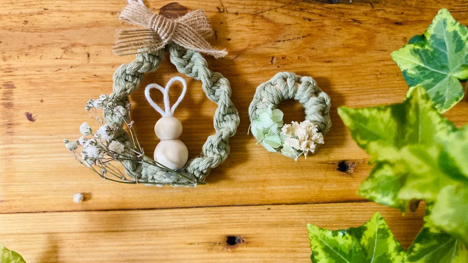 Two wreaths on wooden table with leaves.