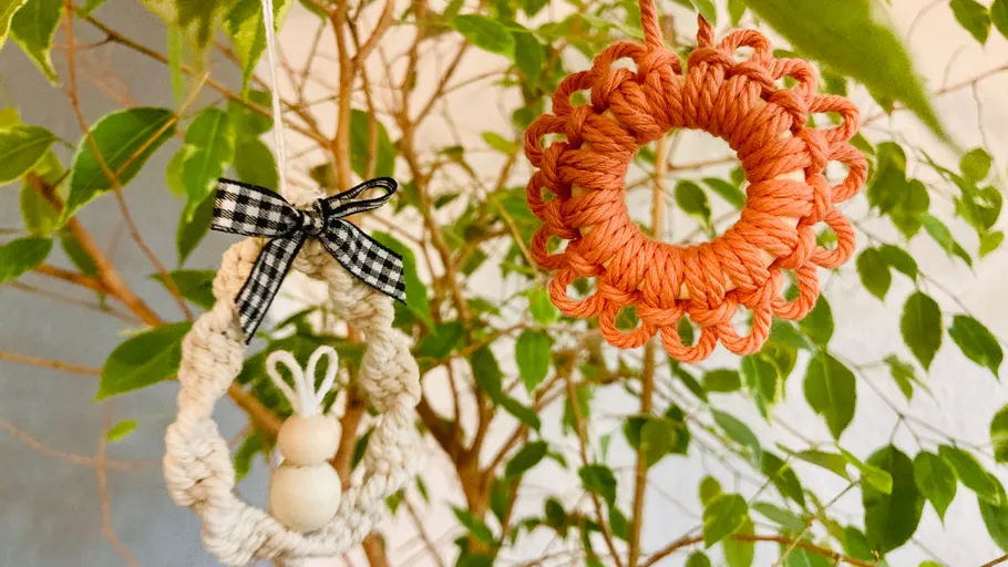 Zwei geflochtene Ornamente am Baum hängend.