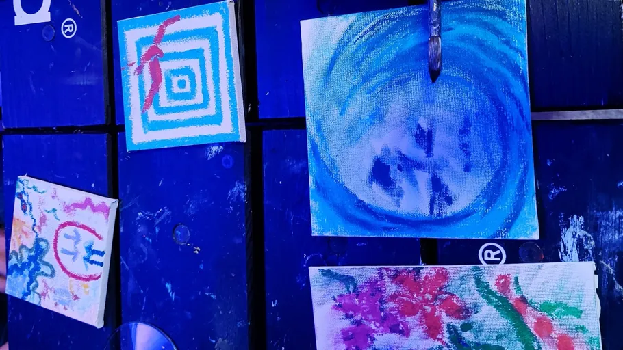 Abstract paintings displayed on a dark surface.