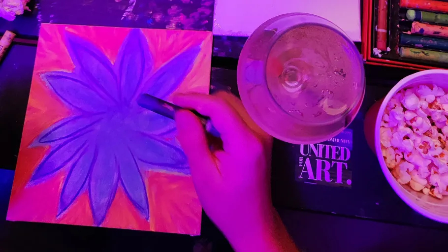 Hand drawing flower under purple lighting.