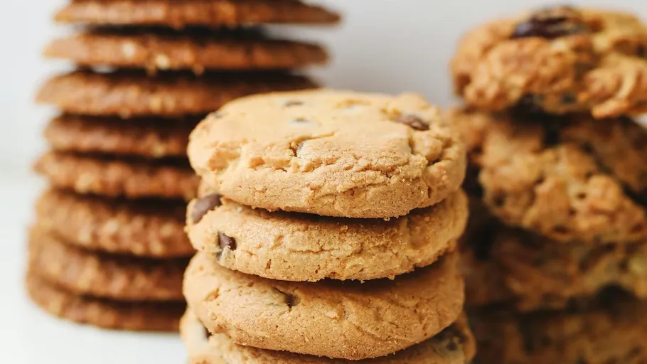 Stacked cookies with chocolate chips on table.