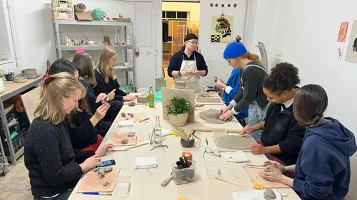 Group crafting clay objects in studio.