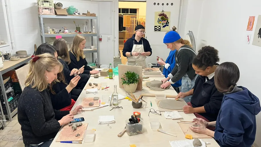 Group crafting clay objects in studio.