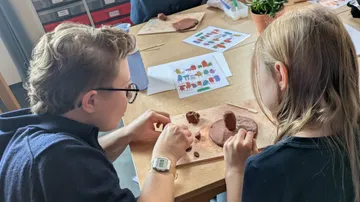 Kinder formen Ton an einem Tisch.