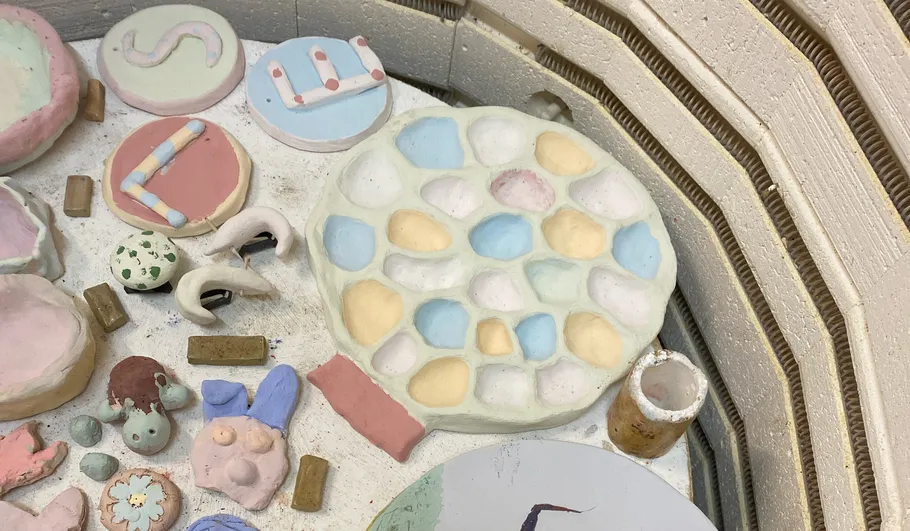 Ceramic pieces in kiln, various colors, unfinished.