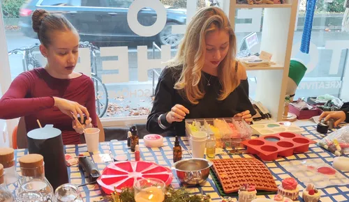 Two women crafting soap at a table.