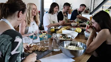 Gruppe kocht und lacht zusammen in der Küche.