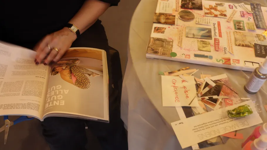 Person crafting with collage materials on table.