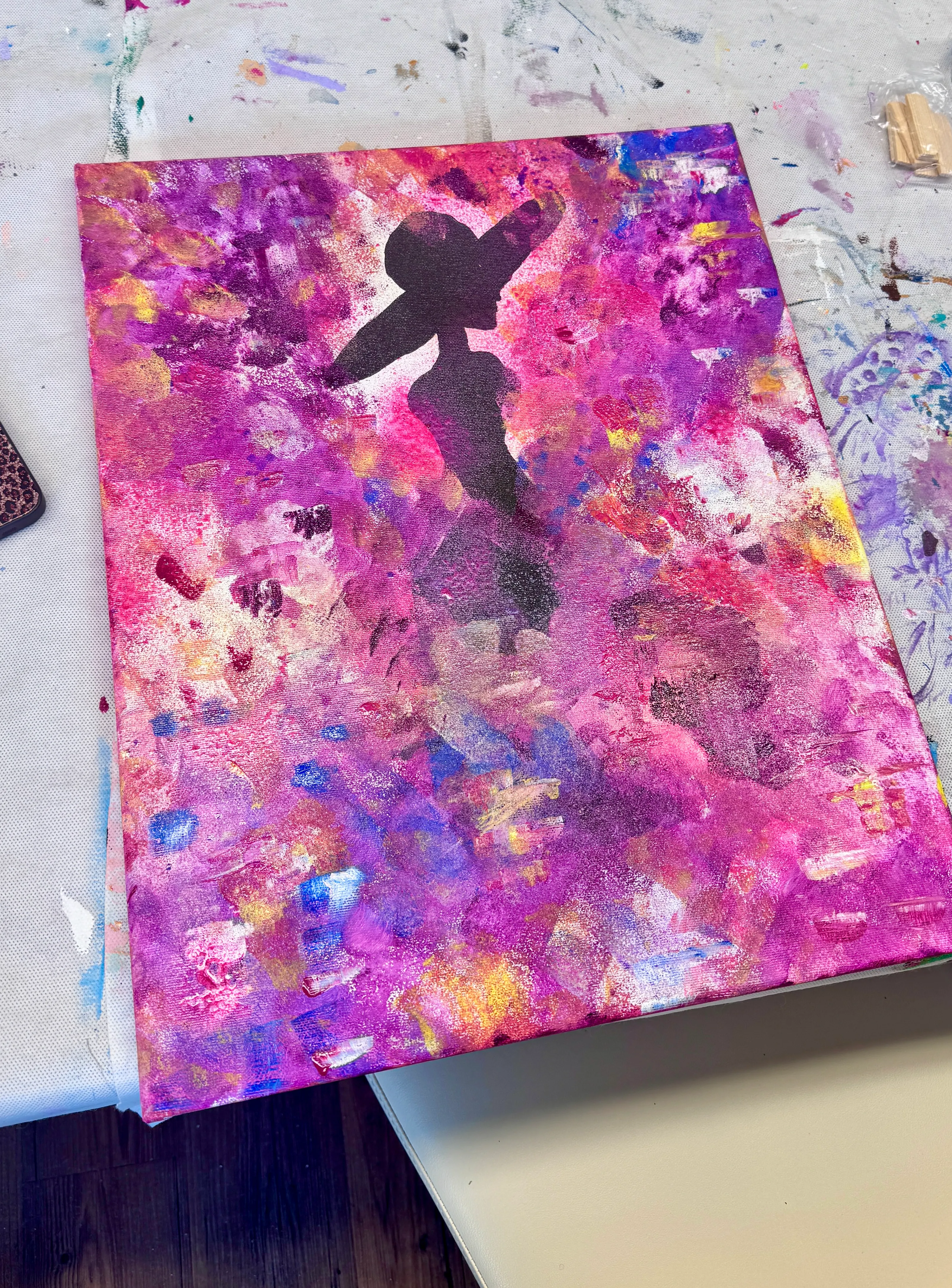 Schattenriss einer Frau mit Hut auf buntem Gemälde.