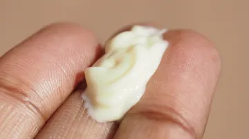 Creme auf Fingern, Nahaufnahme.