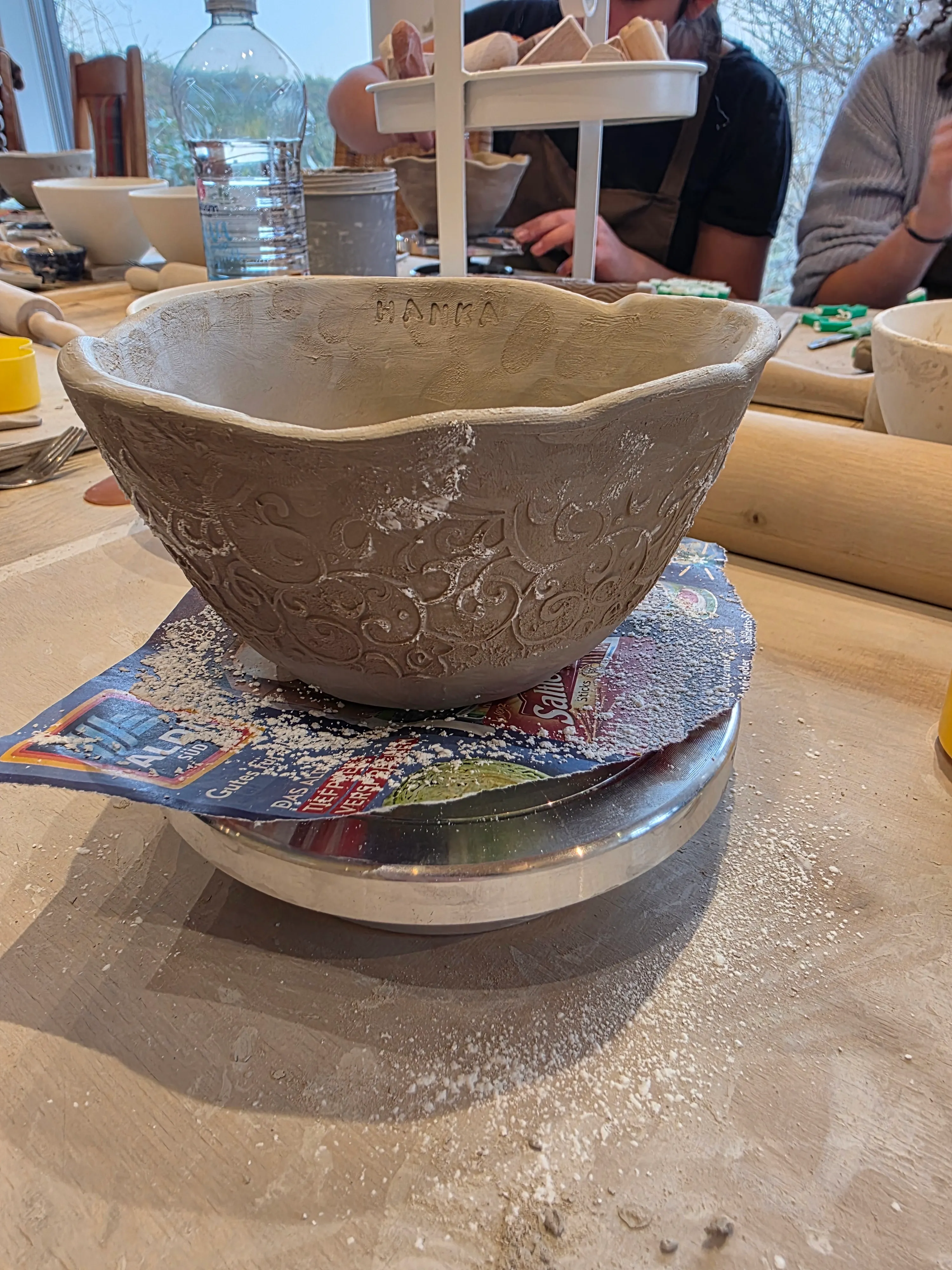 Tonschale auf Drehscheibe im Töpferkurs.