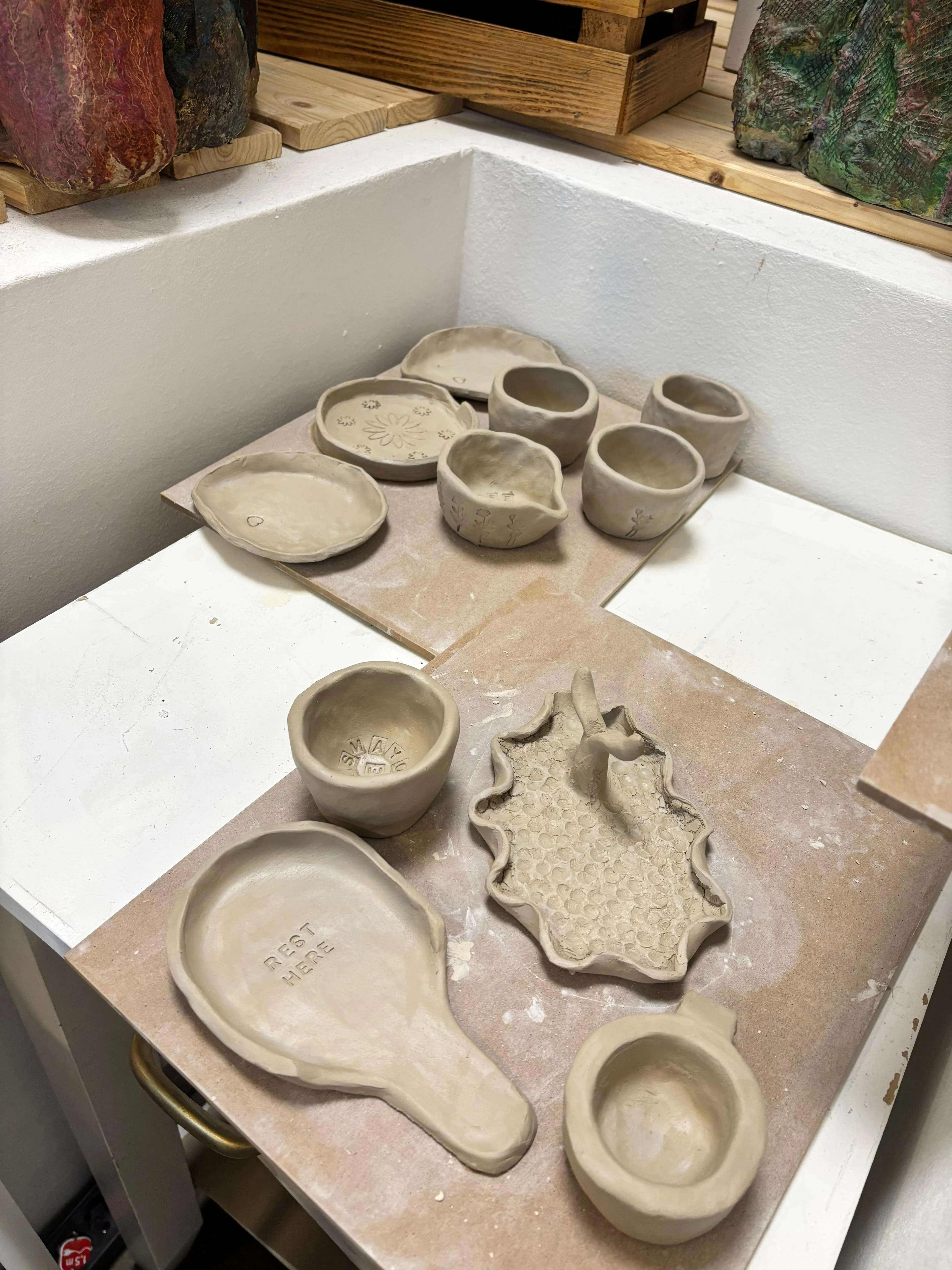 Handgemachte Töpferwaren aus Ton trocknen auf Regalen.