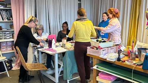 Five women crafting in a colorful studio.