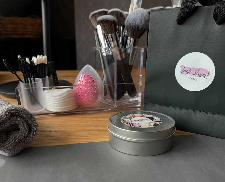 Makeup tools and products on wooden table.