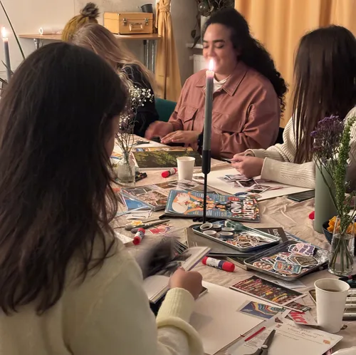 Women crafting at a table with magazines.