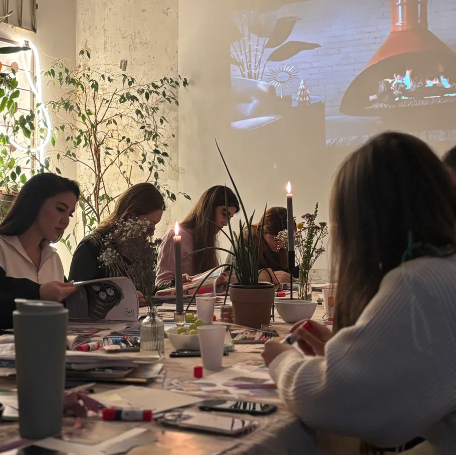 People crafting at a table with candles.
