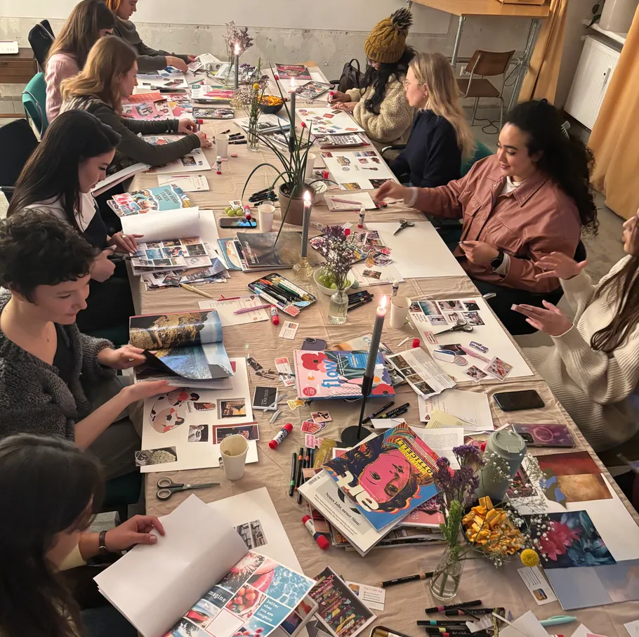 Group crafting collages around a large table.
