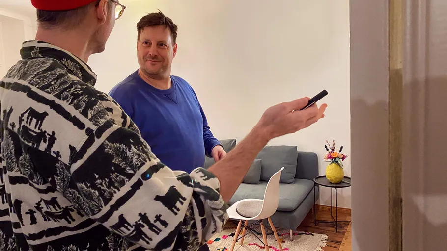 Two men talking in a living room.