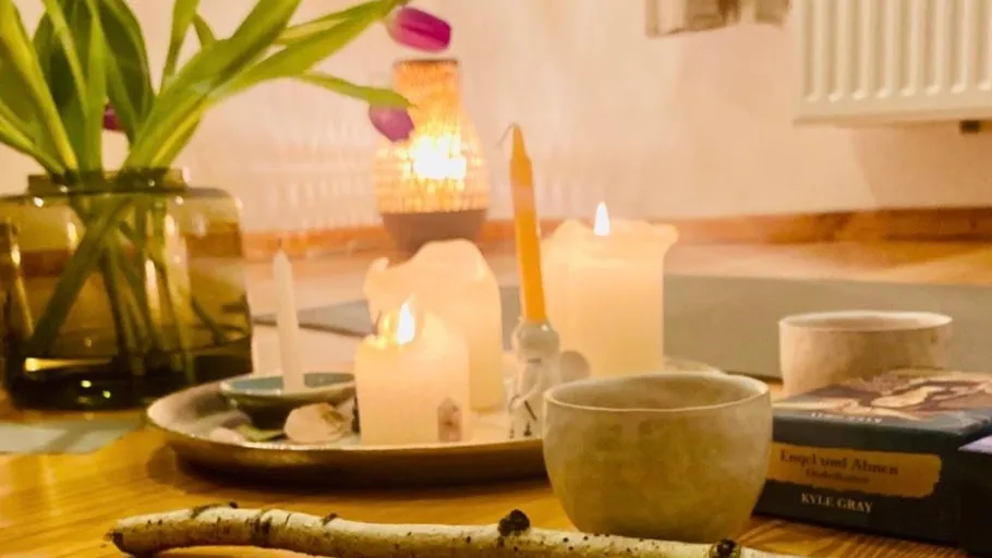 Kerzen und Bücher auf einem Holztisch.