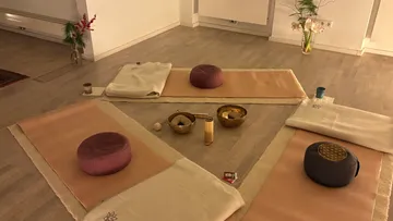 Meditation setup with cushions and mats in room.