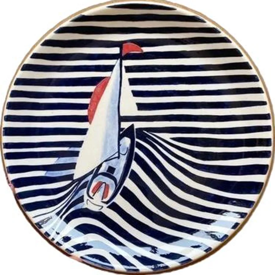 Sailboat design on striped ceramic plate.