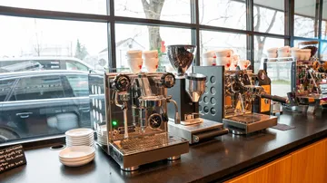 Espressomaschinen in einem Café mit Tassen.