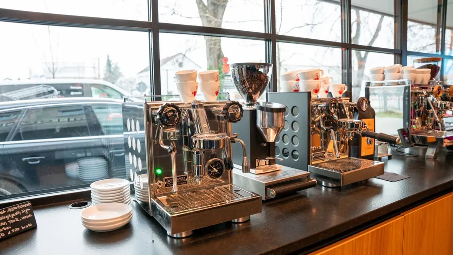 Espresso machines in a café with cups.