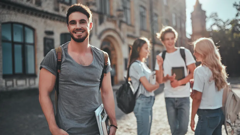 Group of students chatting outside building.
