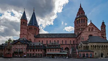 Große Kathedrale mit Doppeltürmen unter bewölktem Himmel.