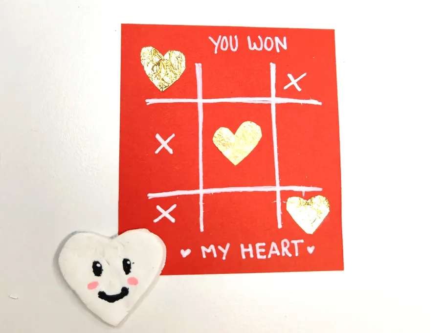Red card with tic-tac-toe heart design.