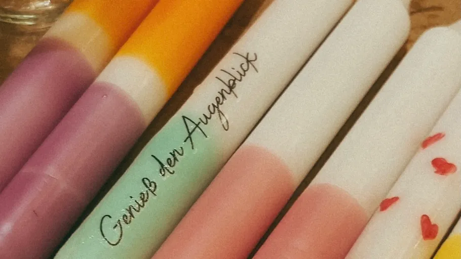 Colorful gradient candles on wooden surface.