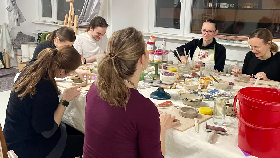 People crafting pottery in a studio setting.