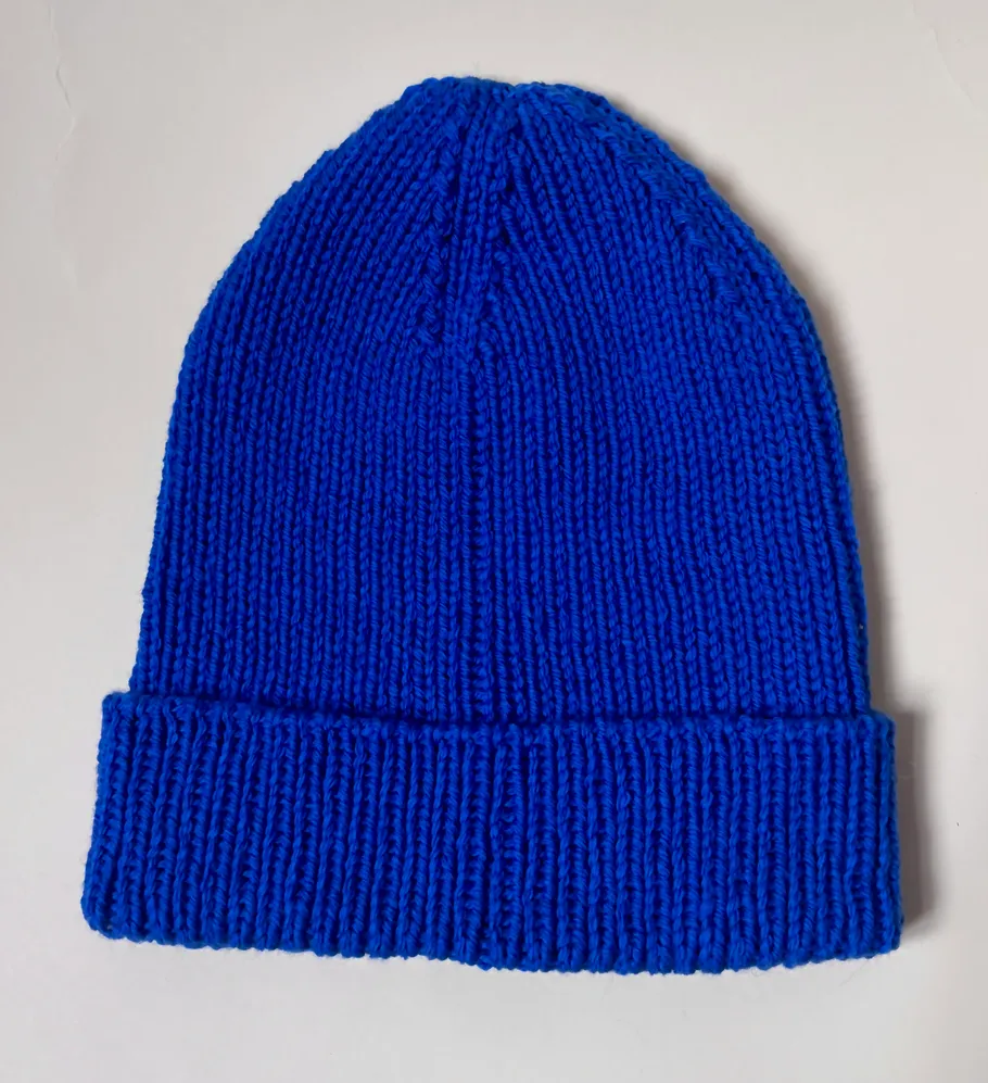 Blaue Strickmütze auf weißem Hintergrund.