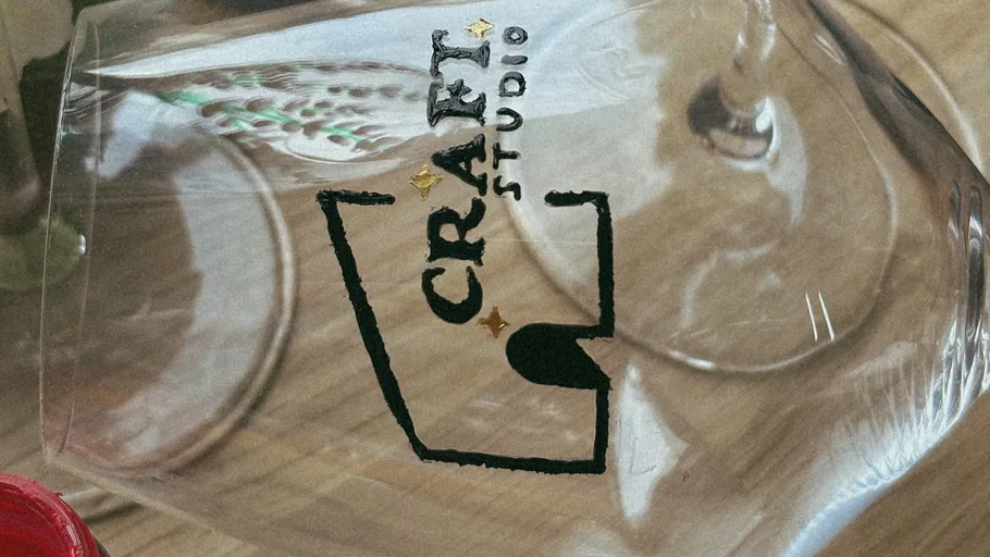 Weinglas mit 'Craft Studio'-Logo.
