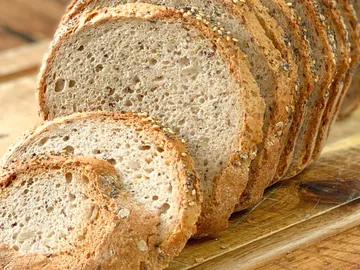 Scheiben Brot liegen auf einem Holzbrett.