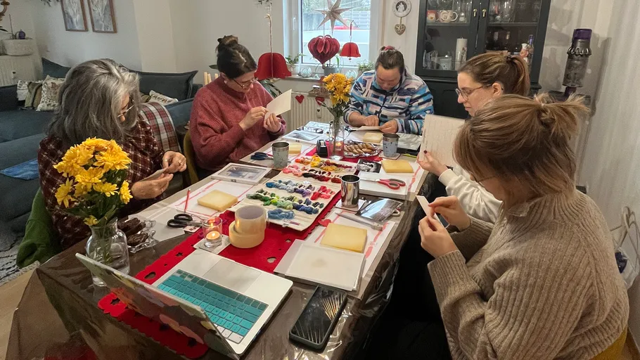 Five women crafting at a dining table.