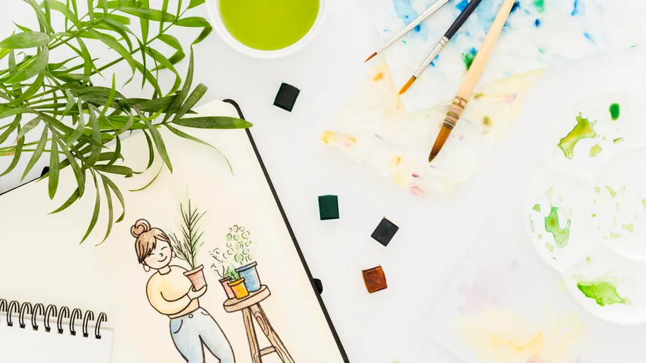 Painting supplies and plant illustration on table.