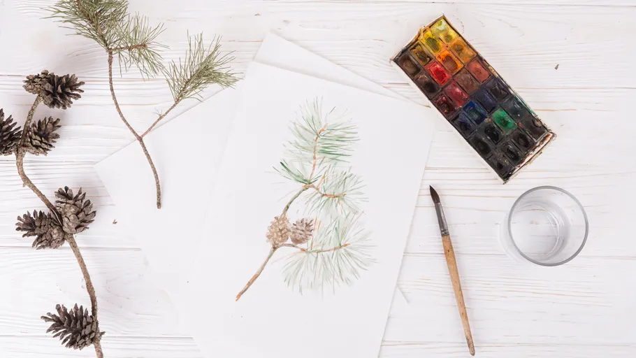 Aquarellgemälde eines Kiefernzweigs auf Tisch.