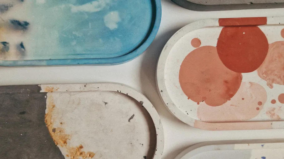 Bunte Harztabletts mit abstrakten Designs, auf Tisch.