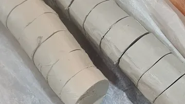 Geschnittene Tonstämme auf einem Tisch.